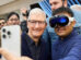 Apple CEO Tim Cook poses for a selfie with a customer wearing a Vision Pro